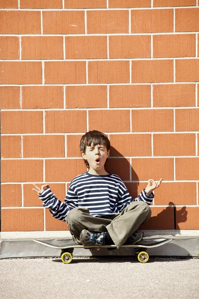 Niño en monopatín, meditación — Foto de Stock