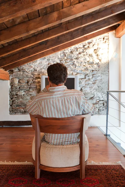 Man titta på en tv på en fåtölj — Stockfoto