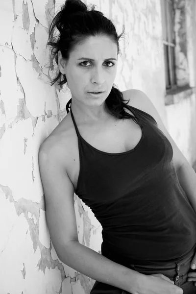 Porträtt av kvinna nära väggen. svart och vitt — Stockfoto