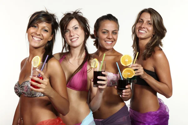 Vier meisjes plezier met een drankje, portret in studio, geïsoleerd op witte achtergrond — Stockfoto