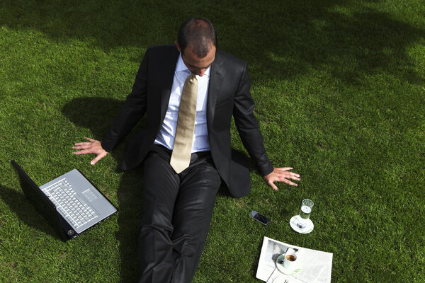 Businessman relaxing on grass