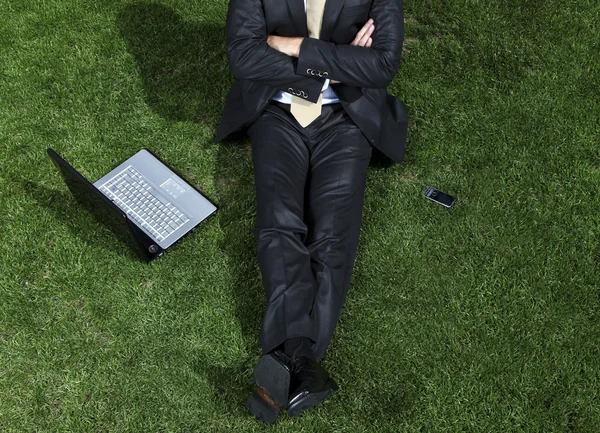 Homme d'affaires relaxant sur l'herbe — Photo