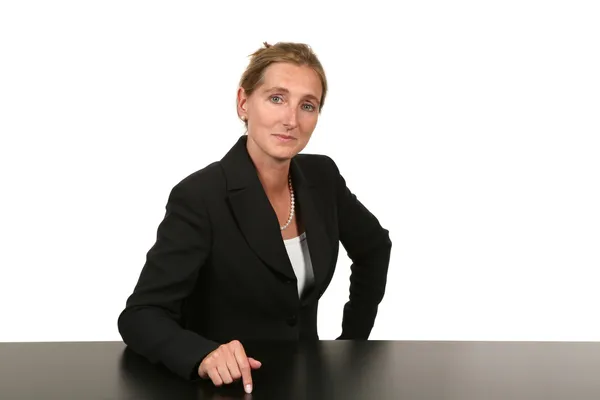 Businesswoman sitting on desk — Stock Photo, Image