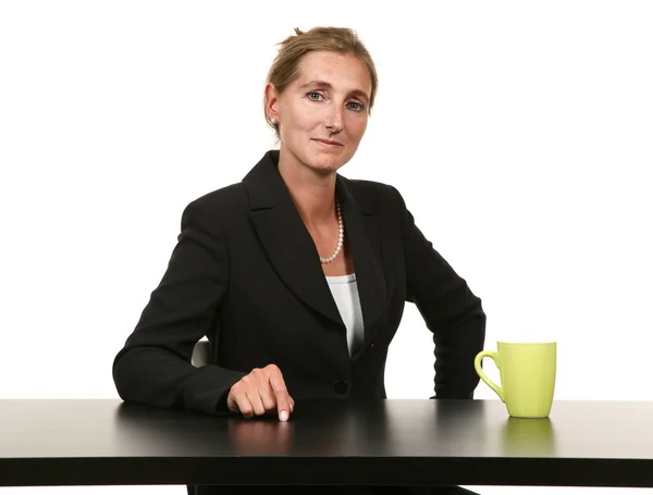 Geschäftsfrau sitzt auf Schreibtisch — Stockfoto