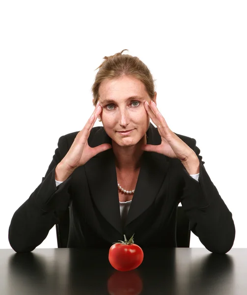 Empresária sentada com tomate na mesa — Fotografia de Stock