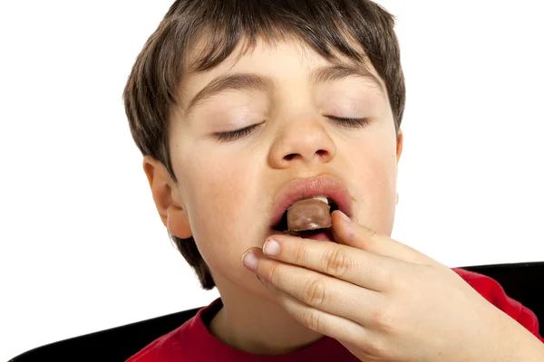 Menino comendo uma vara de chocolate — Fotografia de Stock