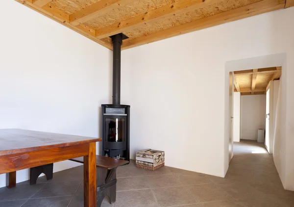 Комната со столом и дровяной печью — стоковое фото