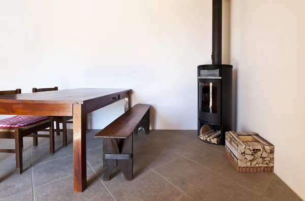 Quarto com mesa e fogão a lenha — Fotografia de Stock