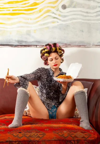 सेक्सी लड़की सोफे पर स्पैगेटी खाने — स्टॉक फ़ोटो, इमेज