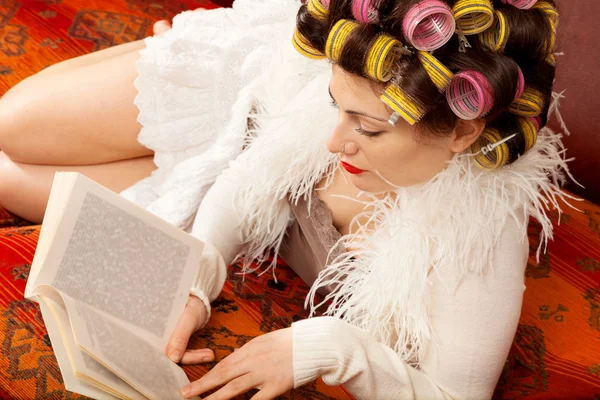 Женщина, читающая на диване — стоковое фото