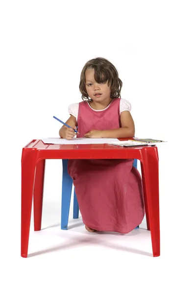 Lille pige ved bordet tegner med farveblyanter - Stock-foto