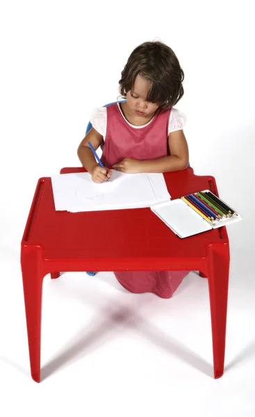 Klein meisje aan de tafel tekent u met kleurpotloden — Stockfoto