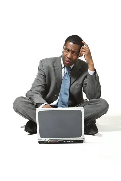 Negro hombre de negocios con portátil piensa — Foto de Stock