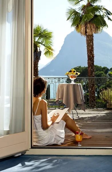 Mooie vrouw lezen op het terras — Stockfoto