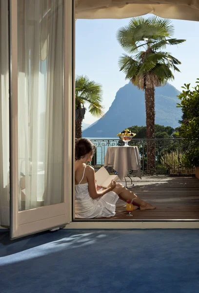 Beautiful woman reading on the terrace — Stock Photo, Image