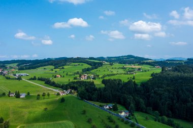 Mavi gökyüzünün olduğu bir yaz gününde yeşil İsviçre tepelerinin panorama hava manzarası. İçeride kimse yok.