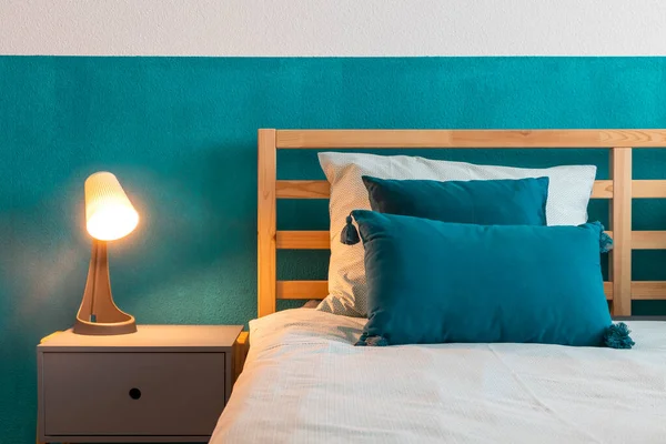 Rincian Tempat Tidur Kayu Dengan Dinding Pirus Dan Banyak Bantal — Stok Foto