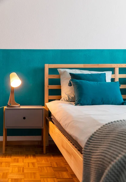 板の上にターコイズ色の壁と多くの枕を持つ木製のベッドの詳細 親密さと静けさの感じ 誰も中に — ストック写真