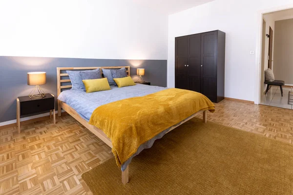Schlafzimmer Mit Grauen Und Gelben Decken Schwarzem Nachttisch Und Brennender — Stockfoto