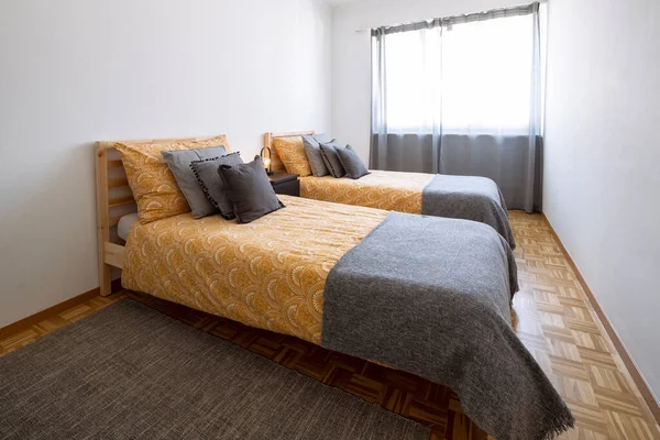2つのシングルベッド 白い壁とグレーと黄色の毛布とベッドルーム ベッドの上に枕 中には — ストック写真