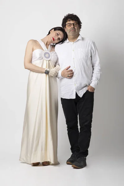 50-year-old couple poses in front of the photographer in a haughty manner worthy of the English lords. White background