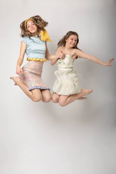 Dvě Mladší Sestry Skákají Radostí Bílým Pozadím Jsou Velmi Šťastní — Stock fotografie