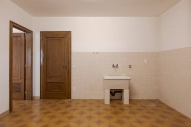 Ön manzara küveti ve iki kapı, biri açık, biri kapalı. İçi boş eski villa yenilenecek. İçeride kimse yok.