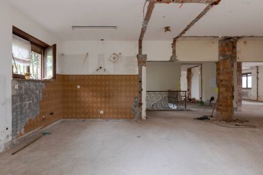Yıkımı ve tadilatı yapılan eski bir villanın birçok penceresi olan büyük, parlak bir oda. Duvarlar yıkıldı ve zemin yıkıldı. İçeride kimse yok.