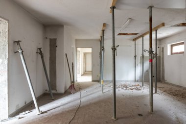 Yıkımı ve tadilatı yapılan eski bir villanın tavanına sabitlenmiş büyük bir oda. Bir sürü toprak ve toz var. İçeride kimse yok.