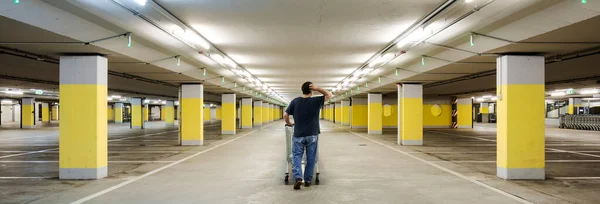Hombre Confundido Camina Con Carrito Compras Estacionamiento Subterráneo Vacío Con — Foto de Stock