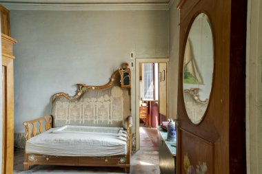 Antika bir kanepesi ve başka bir odaya açılan kapısı olan bir odanın önü. Terk edilmiş bir villanın içi restore edilecek..