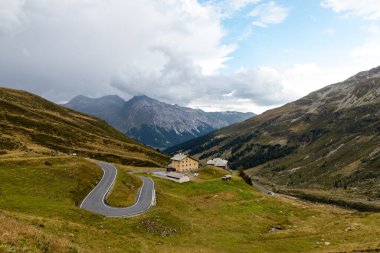 Highest point of the Spluga Pass, on the border between Italy and Switzerland. Alpine panorama on a summer day covered by clouds.