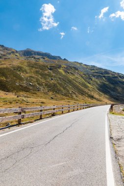 Highest point of the Spluga Pass, on the border between Italy and Switzerland. Alpine panorama on a summer day, blue sky