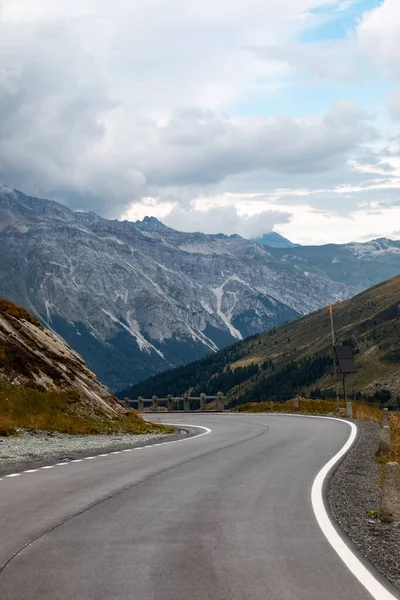 Highest point of the Spluga Pass, on the border between Italy and Switzerland. Alpine panorama on a summer day covered by clouds.