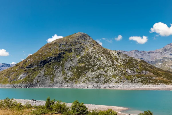 Panoramic view of Montespluga lake on a sunny summer day. The lake is nearly empty due to climate change. Spluga Pass, border between Italy and Switzerland