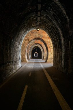 Cycle path in Liguria built on the old train route. Tunnel made from red bricks. Nobody inside