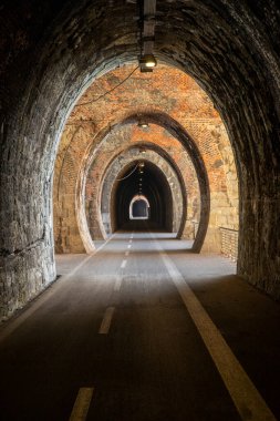 Cycle path in Liguria built on the old train route. Tunnel made from red bricks. Nobody inside