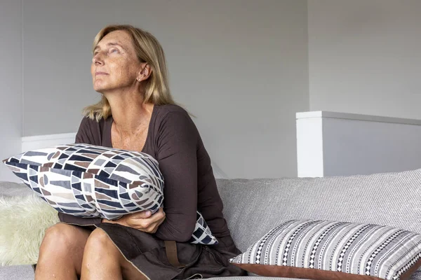 Encantadora Mujer Mediana Edad Sentada Sofá Casa Con Una Almohada —  Fotos de Stock