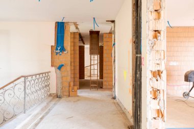 Tadilat altındaki eski bir villanın girişinin önü. Eski duvarlar yıkıldı, yeni duvarlar hala pürüzlü. İçeride kimse yok.