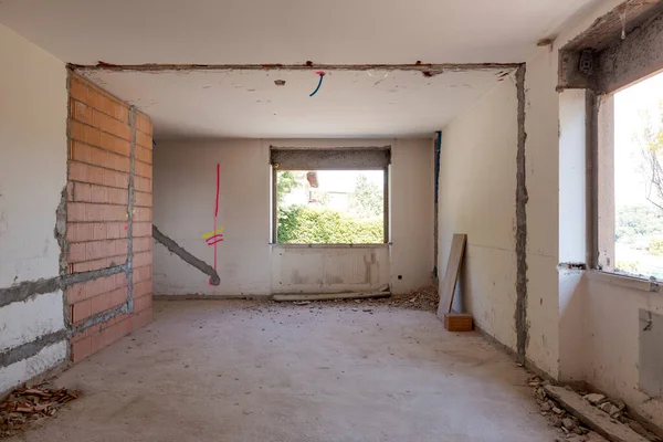 Large bright room with windows of an ancient villa undergoing renovation. The old walls have been torn down and new ones have been created. Nobody inside