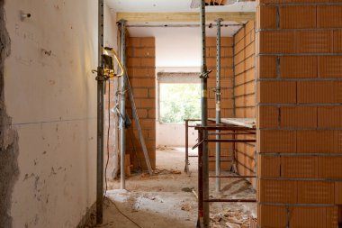 Tadilat altındaki odanın önü hâlâ moloz ve yeni tuğlalarla dolu. İçeride kimse yok.