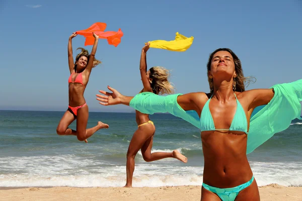 Schöne gebräunte Frauen genießen die Sonne am Strand. lizenzfreie Stockbilder
