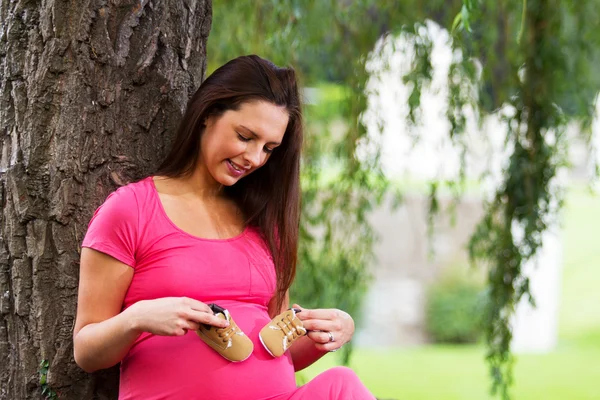 Pregnant woman sitting under a tree — Stock Photo, Image