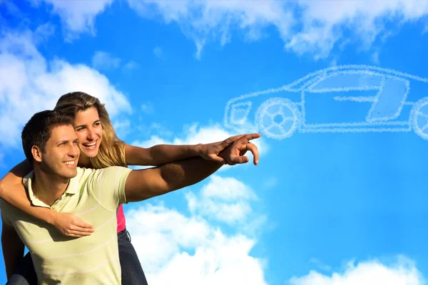 Paar zeigt auf Wolken in Form eines Autos. Stockbild