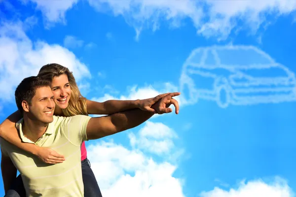 Paar zeigt auf Wolken in Form eines Autos. lizenzfreie Stockfotos
