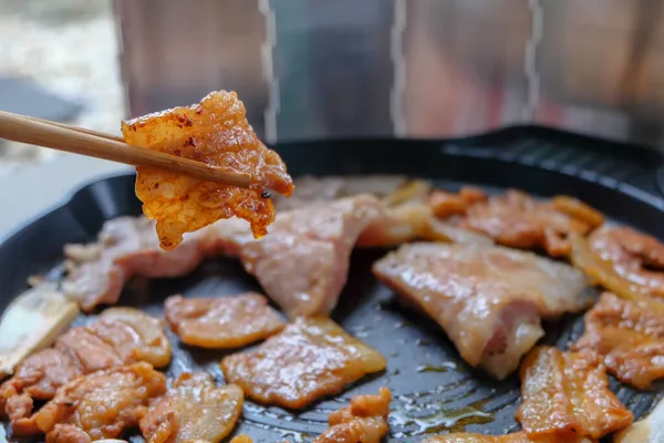 韓国の伝統的なグリルバーベキュー食品 サンジュパル 箸でレタスの豚肉 冬のキャンプのための食品 ロイヤリティフリーのストック写真