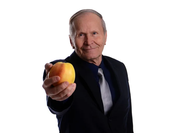 Senior dando una gran manzana amarilla — Foto de Stock