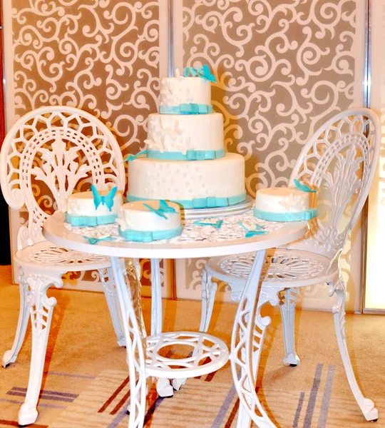 Beyaz ve mavi pasta beyaz masa ve iki beyaz sandalye — Stok fotoğraf