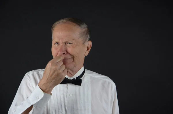 Homme souriant main près du nez — Photo