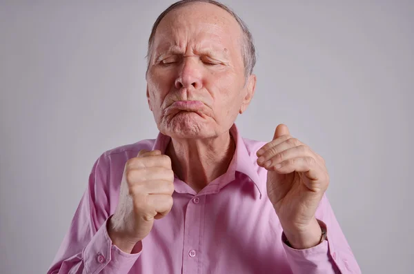 Senior Mann emotionale lustige Gesicht auf grauem Hintergrund — Stockfoto